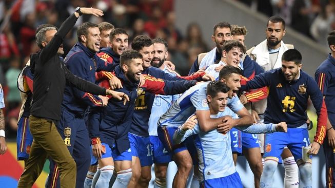 Penyerang Timnas Spanyol Alvaro Morata (berlutut) melakukan selebrasi dengan rekan-rekannya setelah kemenangan timnya atas Portugal dalam matchday keenam Grup A2 UEFA Nations League 2022-2023 di Stadion Kota di Braga pada 27 September 2022. Spanyol menang 0- 1.MIGUEL RIOPA / AFP.