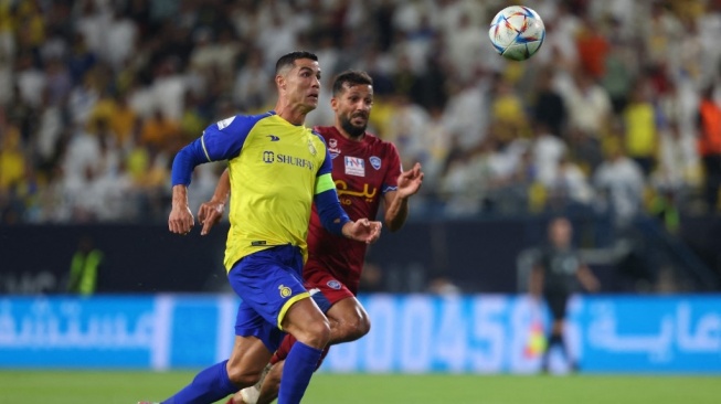 Penyerang Al Nassr, Cristiano Ronaldo (depan) dikejar oleh bek Abha Saad Natiq selama pertandingan sepak bola Liga Pro Saudi antara Abha dan al-Nassr di Stadion Mrsool Park di Riyadh pada 18 Maret 2023.Fayez NURELDINE / AFP.