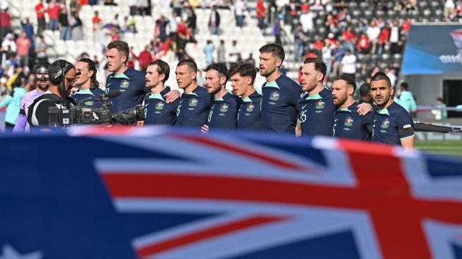 Starting XI timnas Australia menyanyikan lagu kebangsaan mereka sebelum menghadapi Suriah dalam pertandingan Grup B Piala Asia 2023 di Stadion Jassim bin Hamad di Doha pada 18 Januari 2024.HECTOR RETAMAL / AFP.